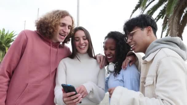 Millennial människor skrattar tillsammans medan du tittar på roligt innehåll på telefon app — Stockvideo