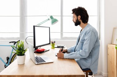 Grafik tablet ve dizüstü bilgisayar kullanan profesyonel yaratıcı tasarımcı