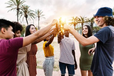Yaz partisinde içki içen bir grup mutlu, çok ırklı genç arkadaş.