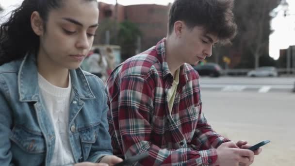 Gruppe von multirassischen Teenagerfreunden, die gemeinsam Mobiltelefone benutzen — Stockvideo