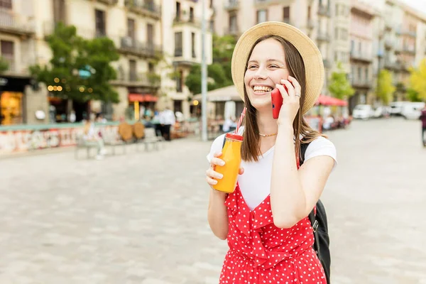 Sokakta yürürken cep telefonuyla konuşan genç bir kadın..