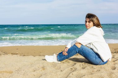 Genç milenyum kadını kumsalda dinleniyor. 