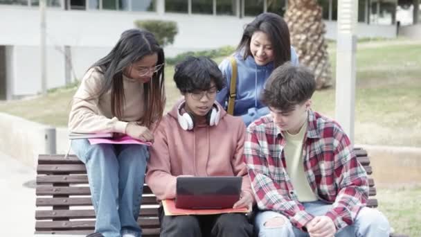 Wieloetniczni studenci studiujący razem na kampusie uniwersyteckim — Wideo stockowe