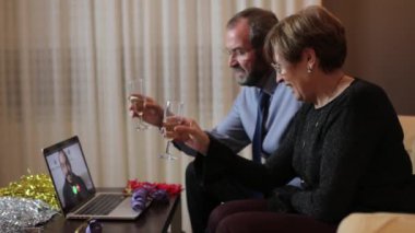 Üst düzey bir çift evde dizüstü bilgisayarla oğluyla video görüşmesi yapıyor doğum günü, yeni yıl arifesi ve Noel konsepti.