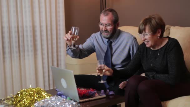 Senior koppel maakt een video gesprek via laptop met hun familie om samen kerst te vieren — Stockvideo
