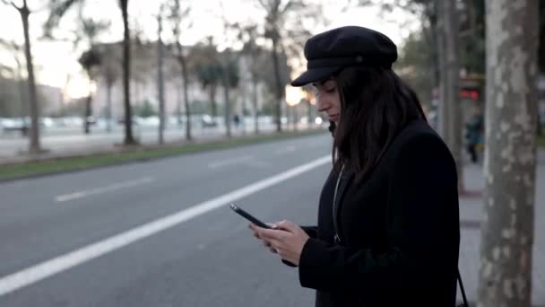 Νεαρή γυναίκα παραγγέλνει ταξί στην πόλη χρησιμοποιώντας την εφαρμογή για κινητά τηλέφωνα — Αρχείο Βίντεο