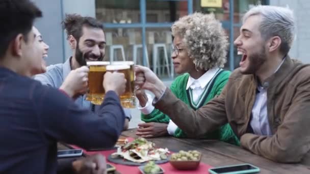 Jovens amigos felizes bebendo cerveja no bar da cervejaria — Vídeo de Stock