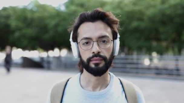 Vooraanzicht van hipster man glimlachend op camera tijdens het lopen in de stad straat — Stockvideo