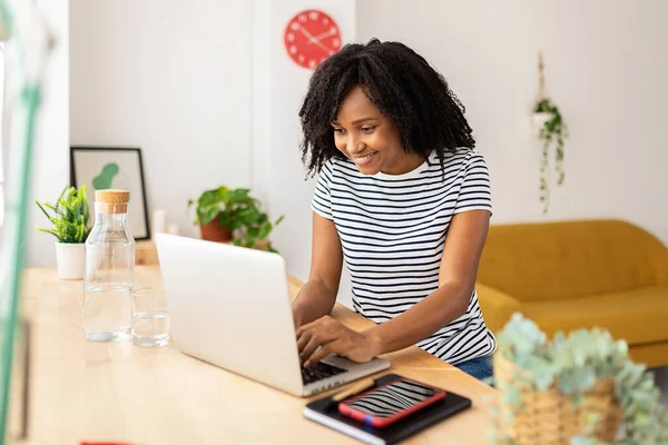 Ev bilgisayarında çalışan Afrikalı Amerikalı kadın.