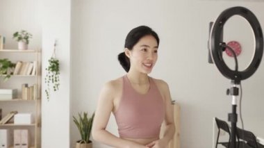 Young fitness instructor streaming online class teaching yoga from home
