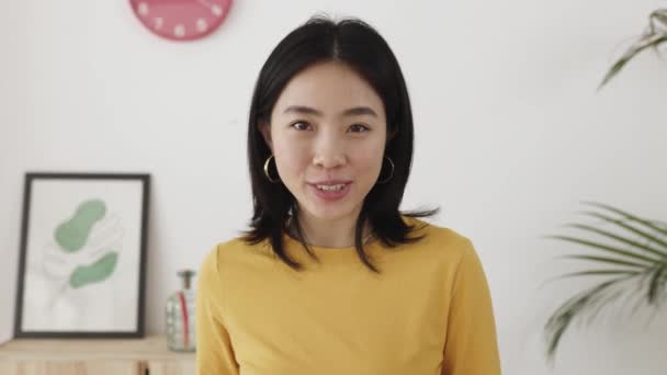 POV jonge aziatische vrouw met een online video gesprek praten met de camera thuis — Stockvideo