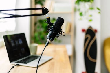 Laptop bilgisayar ve mikrofonlu ev podcast yayın stüdyosu