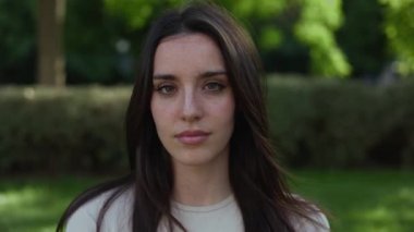 Dışarıda kameraya gülümseyen güzel beyaz kadın.