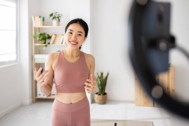 Fitness Asyalı genç kadın oturma odasında online kayıt yapıyor - Sosyal medyada evdeki sağlık tatbikatı hakkında neşeli kadın nüfuzlu kişi - Millennial içerik yaratıcısı insanlar kavramı