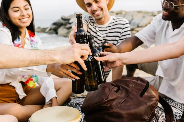 Young friends cheering with beer at the beach while having fun on summer holiday - Millennial people enjoying vacation or weekend together