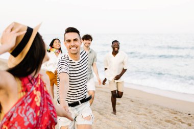 Plajda koşuşturan bir grup genç arkadaş yaz tatillerinde birlikte eğleniyorlar.