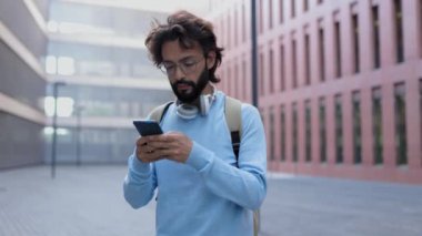 Heyecanlı genç bir adam SMS mesajından iyi haberler alıyor. Finansal bölgede ayakta dururken cep telefonuyla başarıyı kutlayan aşırı neşeli serbest çalışan erkek. Yüksek kalite 4k görüntü