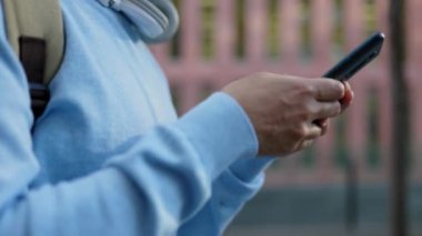 Yavaş çekim kenarı görüntüsü şehir caddesinde yürürken cep telefonu kullanan genç adam ellerini kapat. Yüksek kalite 4k görüntü