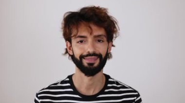 Beyaz arka planda kameraya gülümseyen neşeli, genç bir hippi. Kafkasyalı mutlu adamın portresi. Yüksek kalite 4k görüntü