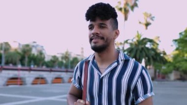 Yazın açık havada dolaşan kendinden emin, Afro-Amerikan bir adam. Yüksek kalite 4k görüntü