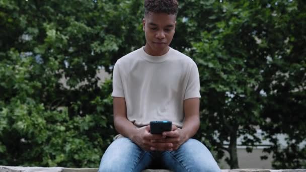 Sorrindo Jovem Menino Adolescente Afro Americano Usando Telefone Celular Inteligente — Vídeo de Stock