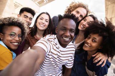 Bir grup mutlu genç açık havada selfie çekiyorlar - Milenyum çeşitliliği en iyi arkadaşlar tatilde eğleniyor - topluluk, arkadaşlık ve birlik konsepti