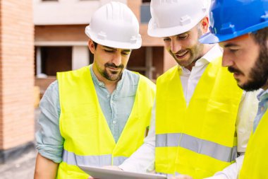 Group of construction architect engineers people working on building site