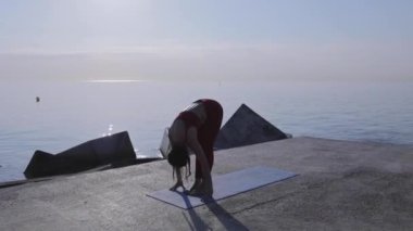 Plajda yoga yapan İspanyol kadın, sağlık ve sağlık hizmetleri konsepti. Yüksek kaliteli FullHD görüntüler