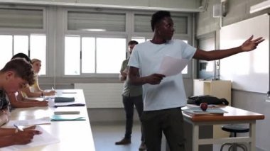 African high school student man giving a presentation at technology subject course. Teenage boy presenting a work at college lesson. Group of student people attending in class. High quality 4k footage