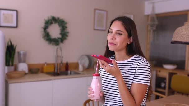 Happy Young Woman Drinking Smoothie While Using Mobile Phone Kitchen — Vídeos de Stock