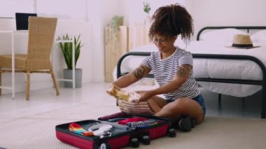 Young woman packing luggage at home before going on holidays. Travel and vacation concept. High quality 4k footage
