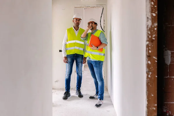 Professional engineer architect workers in conversation at building construction site