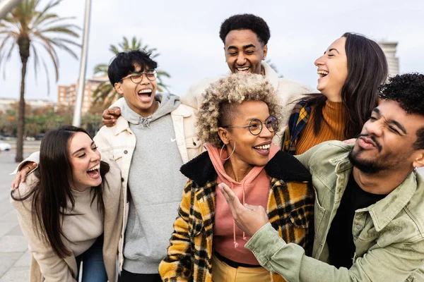 Group of happy friends laughing and hanging out outdoor - Multiracial young people having fun together during travel vacation in city street