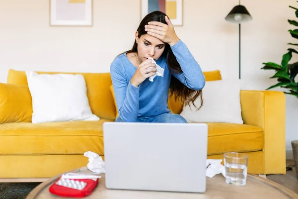 Sick woman holding thermometer while having an online medical consultation with doctor - Online medical consultation, telemedicine and health care concept