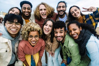 Young multiracial people having fun together outdoor - Big group portrait of happy young student friends taking photo together at city street
