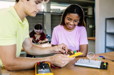Teknoloji sınıfında elektronik devreler öğrenen çeşitli genç öğrenciler - Eğitim teknolojisi kavramı