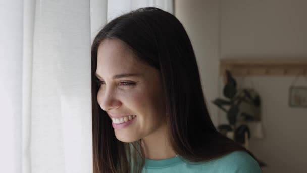Gülümseyen Genç Bir Kadın Evdeki Pencereden Bakıyor — Stok video