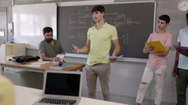 Sınıfta sunum yapan çok ırklı bir grup genç öğrenci. Lise öğrencileri sınıf arkadaşlarına iş projesinden bahsediyorlar. Takım çalışması ve eğitim kavramı. 