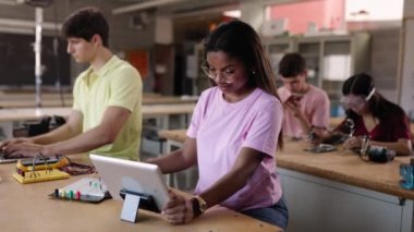 Lisede birlikte elektronik devreler yapmayı öğrenen bir grup öğrenci - Asya ve Afrika kökenli Amerikalı sınıf arkadaşı