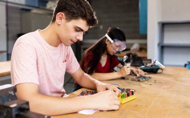 Fen robotiği veya elektronik mühendisliği sınıfında çeşitli lise öğrencileri öğreniyor.