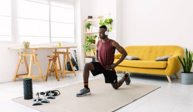 Spor ve sağlıklı yaşam tarzı konsepti için evde spor yapan Afrikalı genç bir adam.
