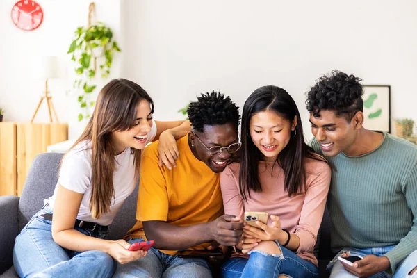 Молода Тисячолітня Група Багаторасових Друзів Розважаються Допомогою Мобільного Телефону Вдома — стокове фото