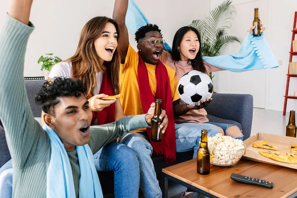 Diverse young group of football fans friends watching soccer on television TV at home - Excited multiethnic people screaming and celebrating goal of their national team