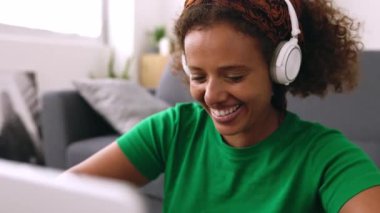 Gülümseyen Afro-Afrikalı genç bir kadın evde dizüstü bilgisayar kullanarak öğreniyor. Yüksek kalite 4k görüntü