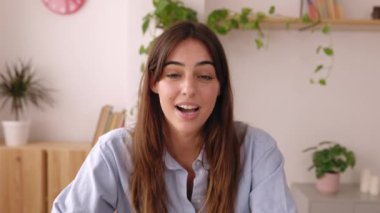 POV ya da portre görüntüsü evde dizüstü bilgisayarla konuşan genç ve güzel bir kadının görüntüsü. İş adamları ve sanal konferans konsepti. 