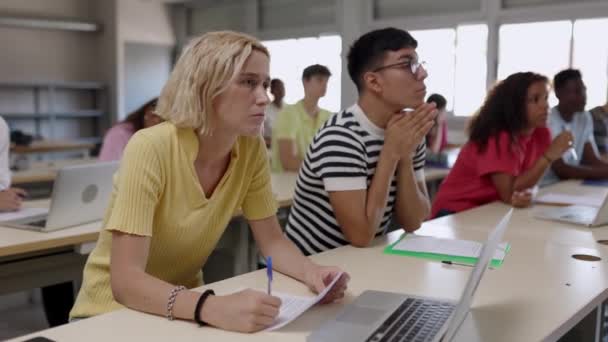 Estudiante Joven Caucásica Haciendo Una Pregunta Maestra Mientras Grupo Estudiantes — Vídeos de Stock