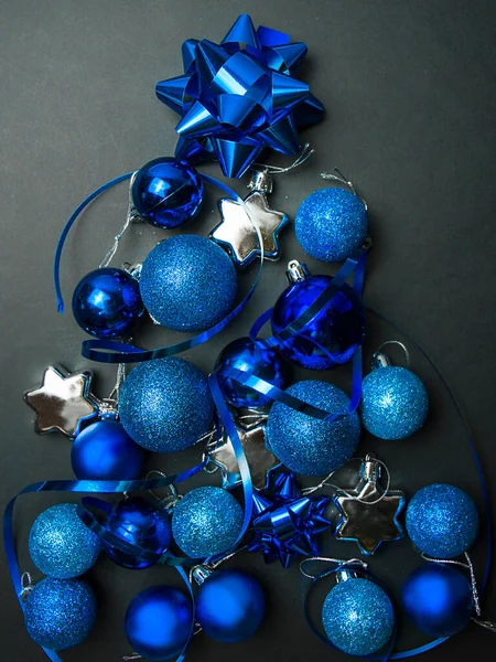蓝色圣诞树玩具在深色背景下的圣诞构图 圣诞树的概念 圣诞节的背景横幅布局 明信片 平躺在床上 — 图库照片