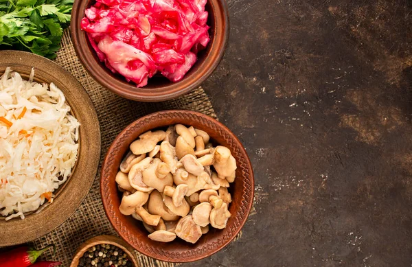 Mantar turşusu, lahana turşusu, masada pancar olan lahana salatası. Mayalanmış yiyecek. Ev yapımı yemek. Sebze turşusu. Üst manzara, düz yatış. Uzayı kopyala Mutfak arka planı.