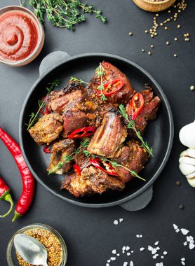 Tavada pişmiş pirzola. Baharatlı ve otlu kızarmış domuz pirzolası ve koyu bir arka plan. Yemek arkaplanı. Yukarıdan bak. Boşluğu kopyala.