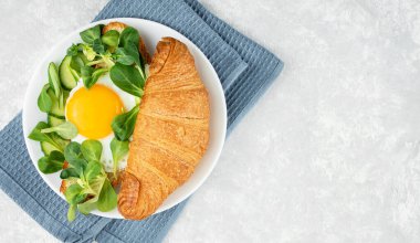 Taze kruvasan, reçel ve portakal suyuyla Avrupa kahvaltısı. Işık masasında kahvaltı, üst manzara. Yemek arkaplanı. Boşluğu kopyala.